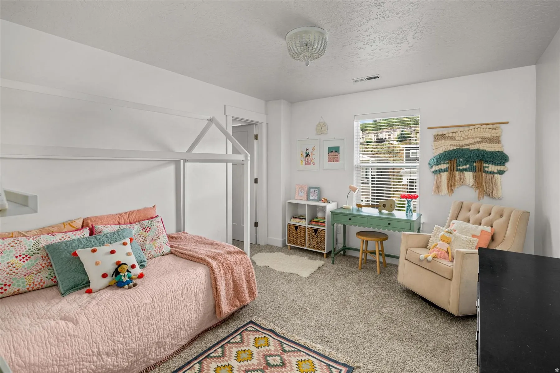 White painted walls, carpeted flooring, and a single window with blinds
