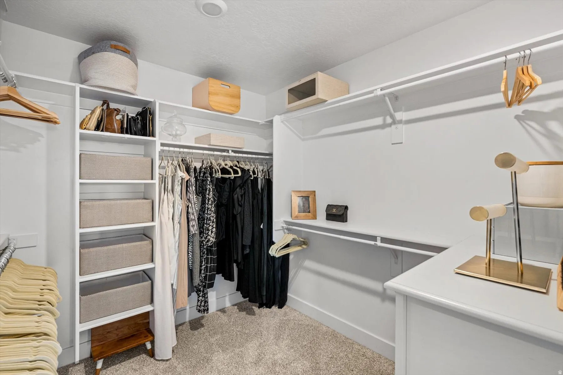 Custom closet system with white shelving, hanging rods, and built-in drawers