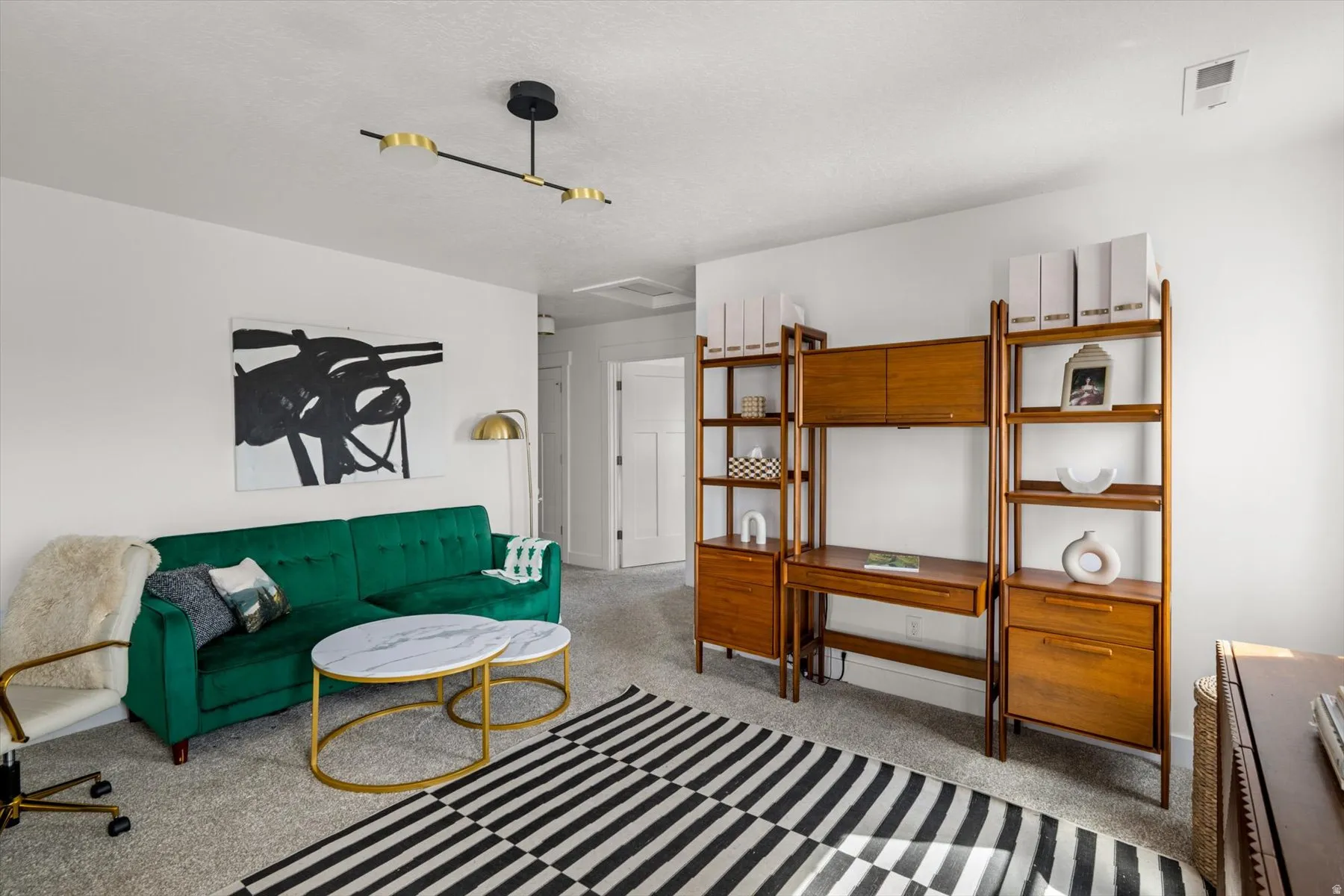 Recessed ceiling light fixture, wood-finish shelving unit, light gray carpet, and white walls