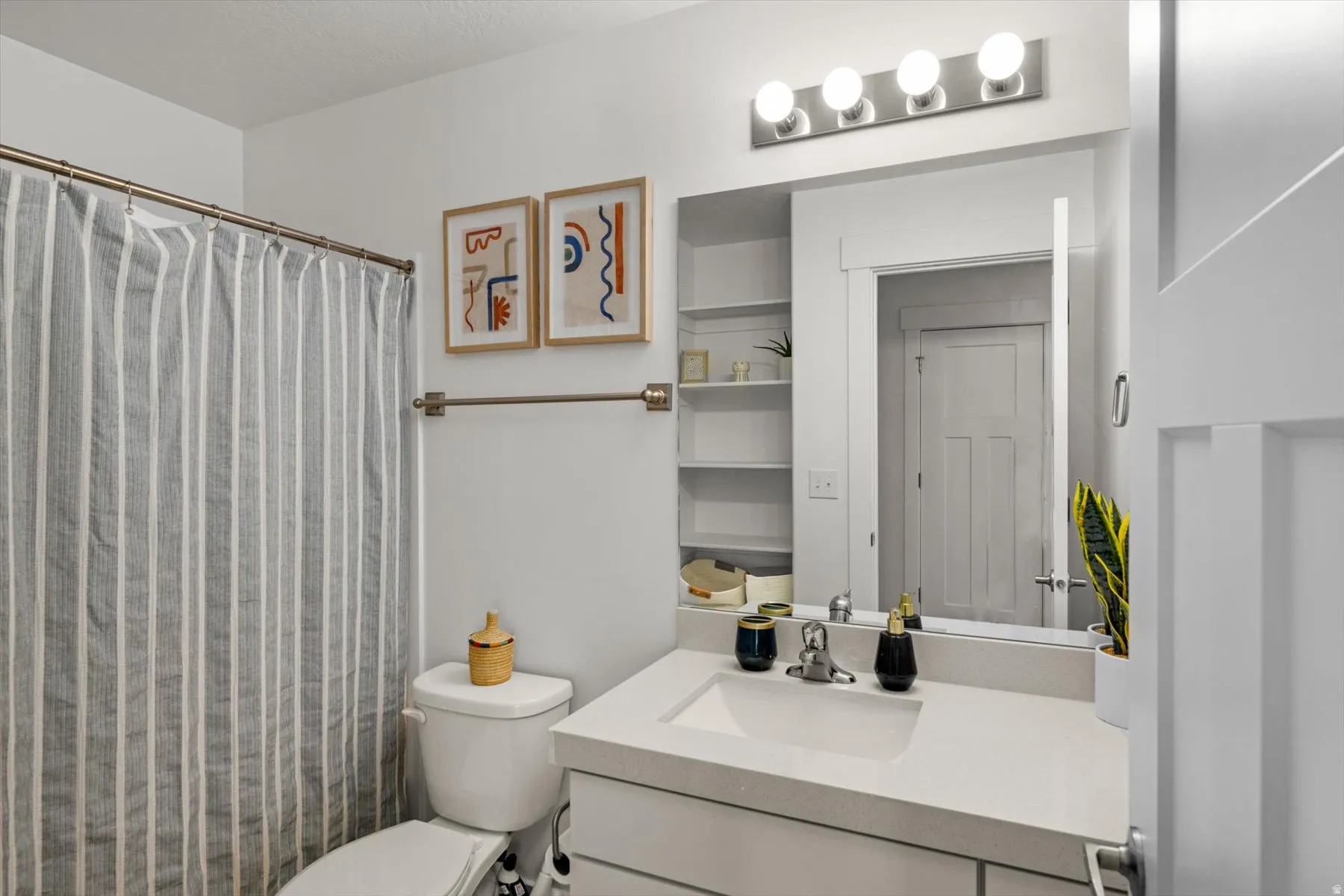 White vanity with an integrated sink, polished chrome faucet, and quartz countertop