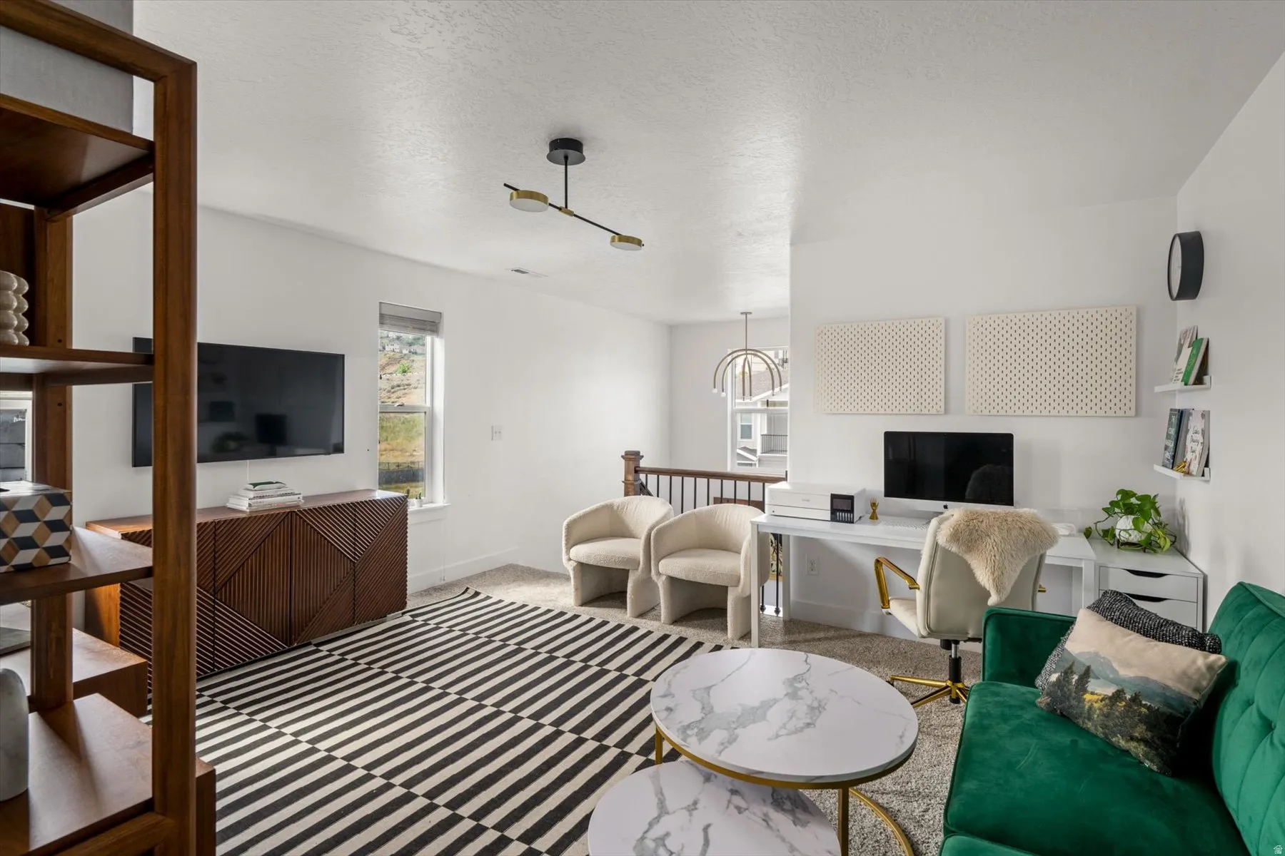 Carpeted flooring, contemporary light fixture, built-in shelving, white walls, and a window with natural light