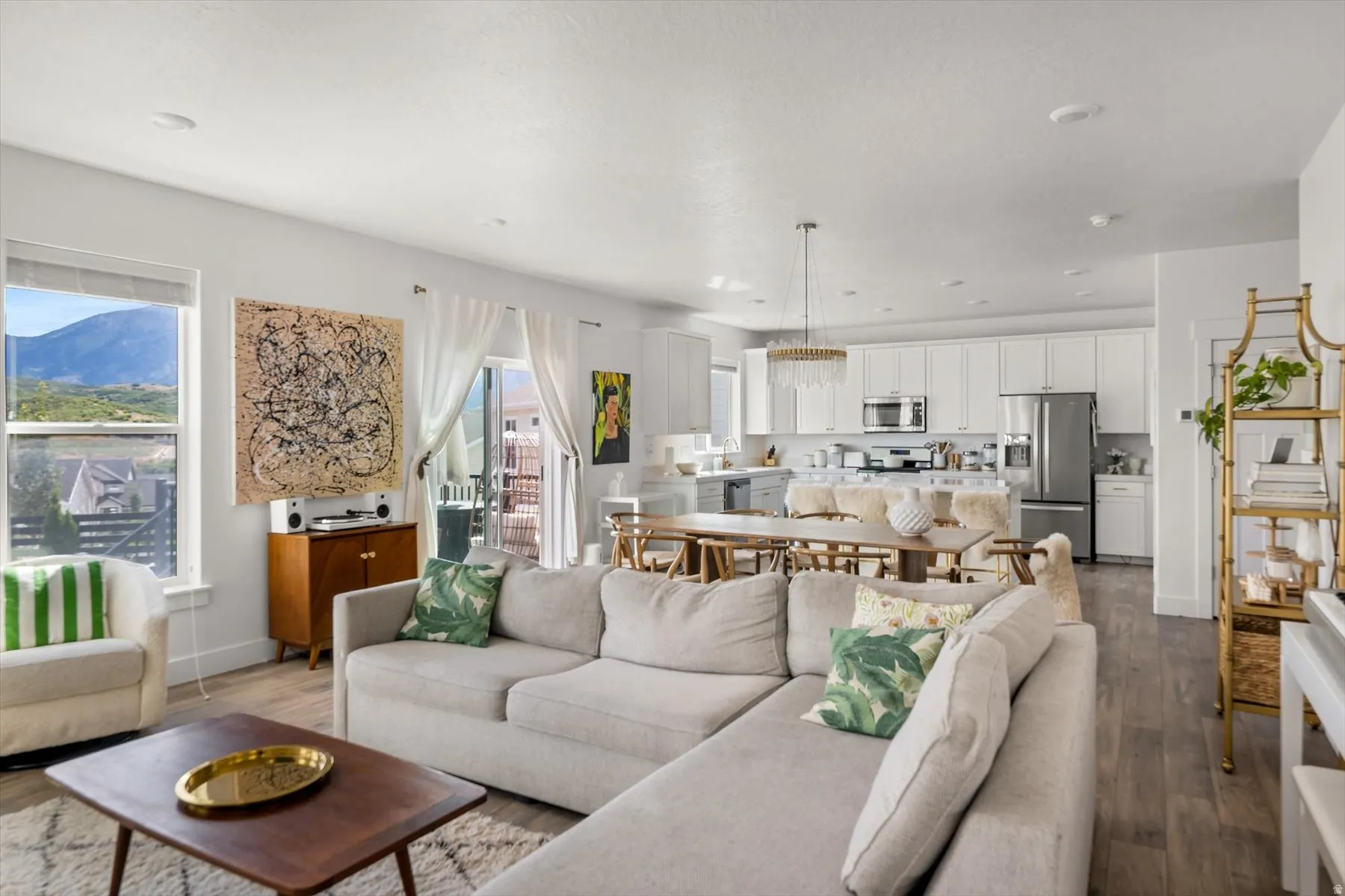 Open-concept living space featuring wood-finish flooring, recessed lighting, and a sliding glass door