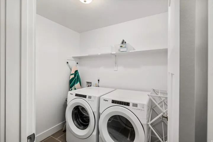 Dedicated laundry area featuring a shelf, overhead lighting, and tiled flooring