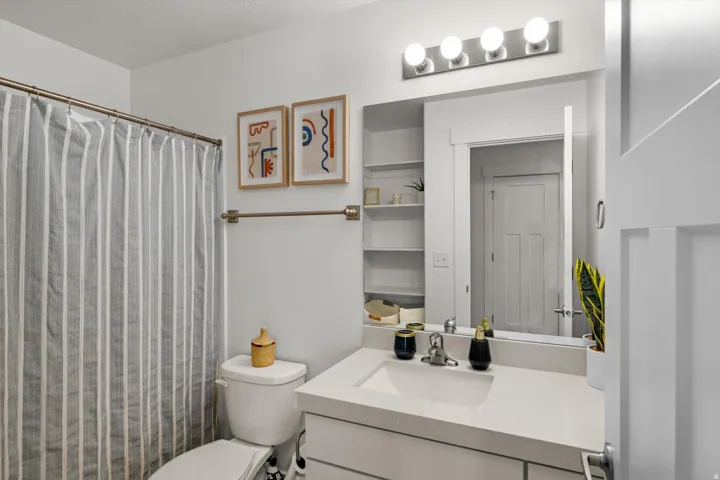 White vanity with an integrated sink, polished chrome faucet, and quartz countertop