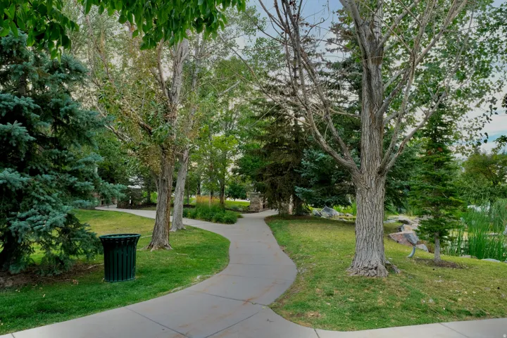 SunCrest community grounds featuring winding walkways, mature trees, open lawns for picnics and gathering, and landscaped green space used for farmers markets, outdoor concerts, and neighborhood events.