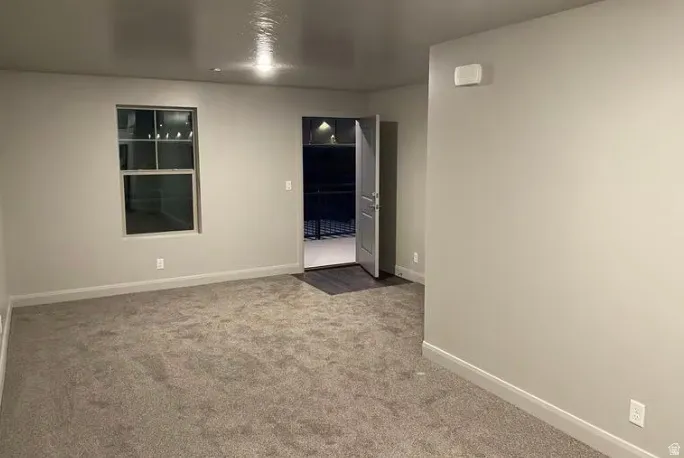 Carpeted flooring, neutral wall tones, recessed lighting, and a single window