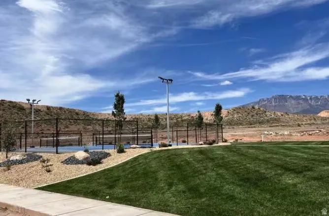 Full-size outdoor courts with chain-link fencing, mature trees, and surrounding rock landscaping