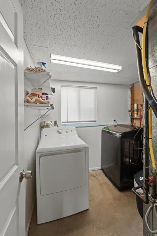 Laundry area with window, fluorescent lighting, and built-in shelving