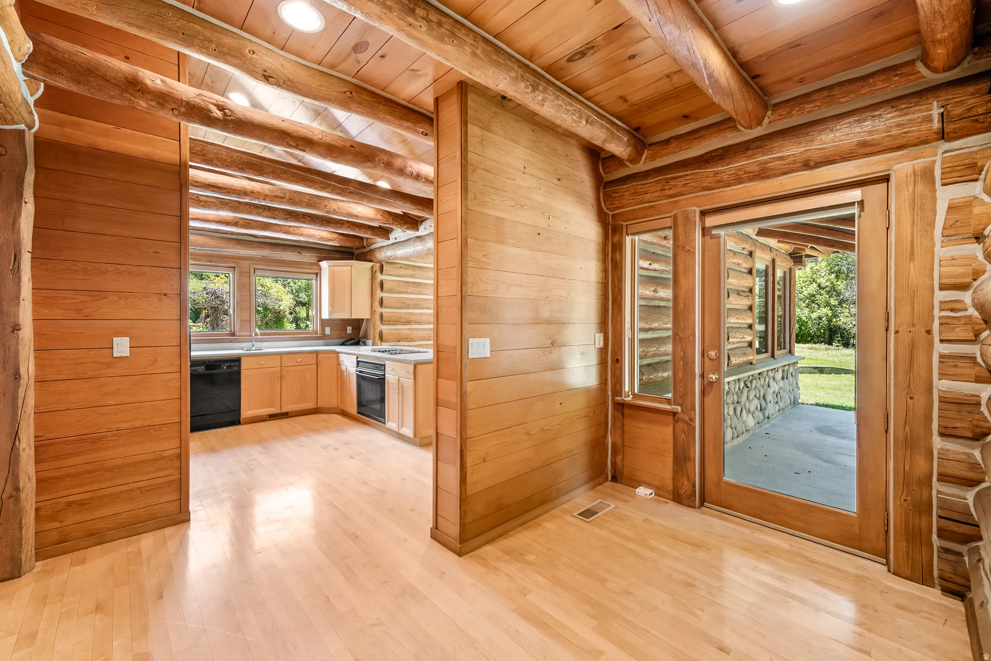 Exposed log beams complement wood-finish flooring throughout this interior space