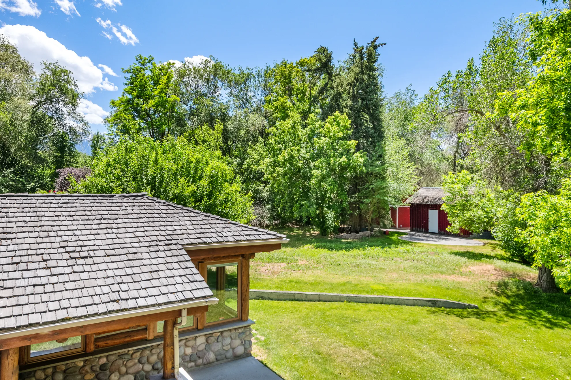 Cedar shake roof covering a structure with natural wood beams and a river rock foundation