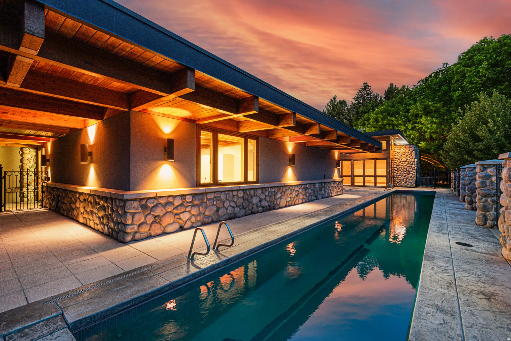 Exterior featuring a stone-clad base, exposed wood beams, and an outdoor swimming pool