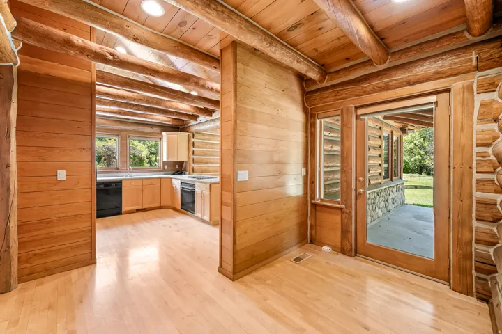 Exposed log beams complement wood-finish flooring throughout this interior space