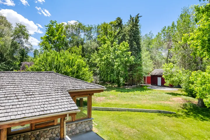 Cedar shake roof covering a structure with natural wood beams and a river rock foundation