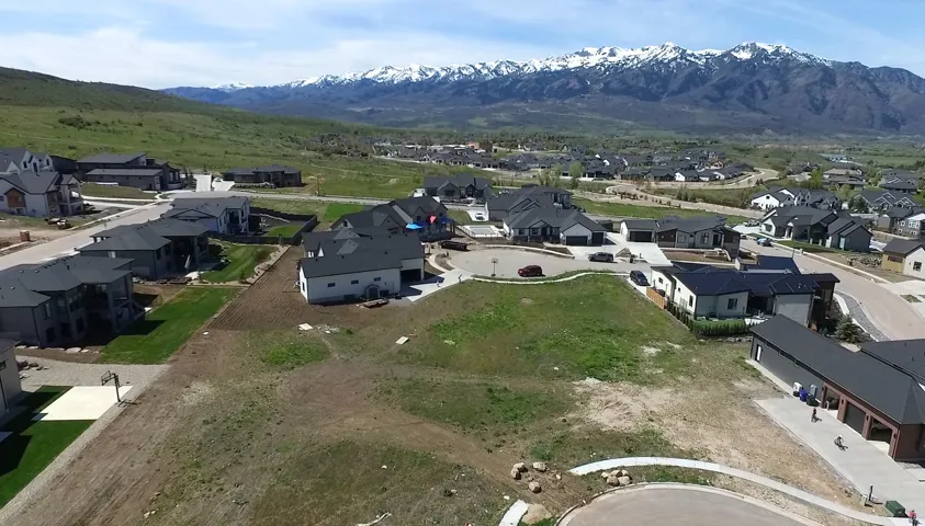 Expansive mountain scenery with residential properties featuring dark-toned roofing and light-colored exteriors