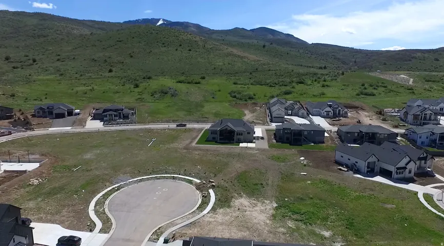 Newly developed residential area with modern homes, paved roads, and natural mountainous surroundings