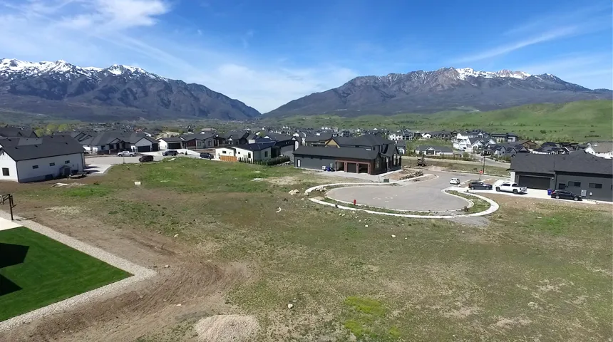 Expansive land parcel within a developed residential area, featuring a level grade and established hardscaping
