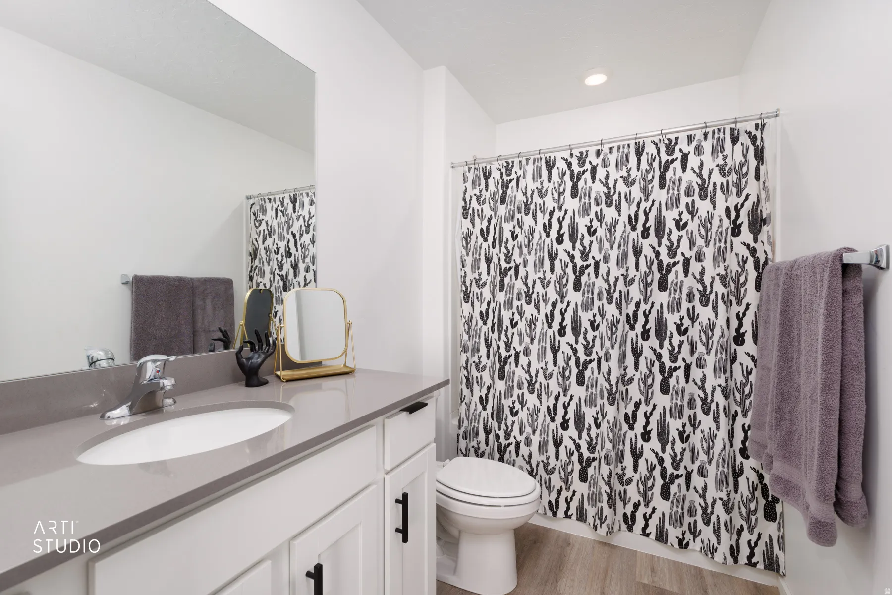 White vanity with dark hardware, undermount sink, integrated faucet, and a large wall-mounted mirror