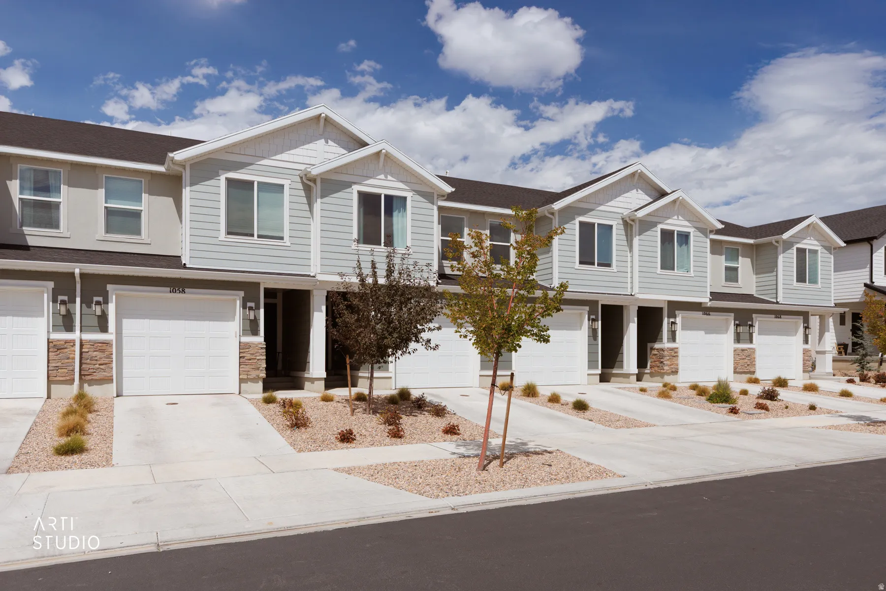 Townhome exterior featuring light-colored siding and a dark roof