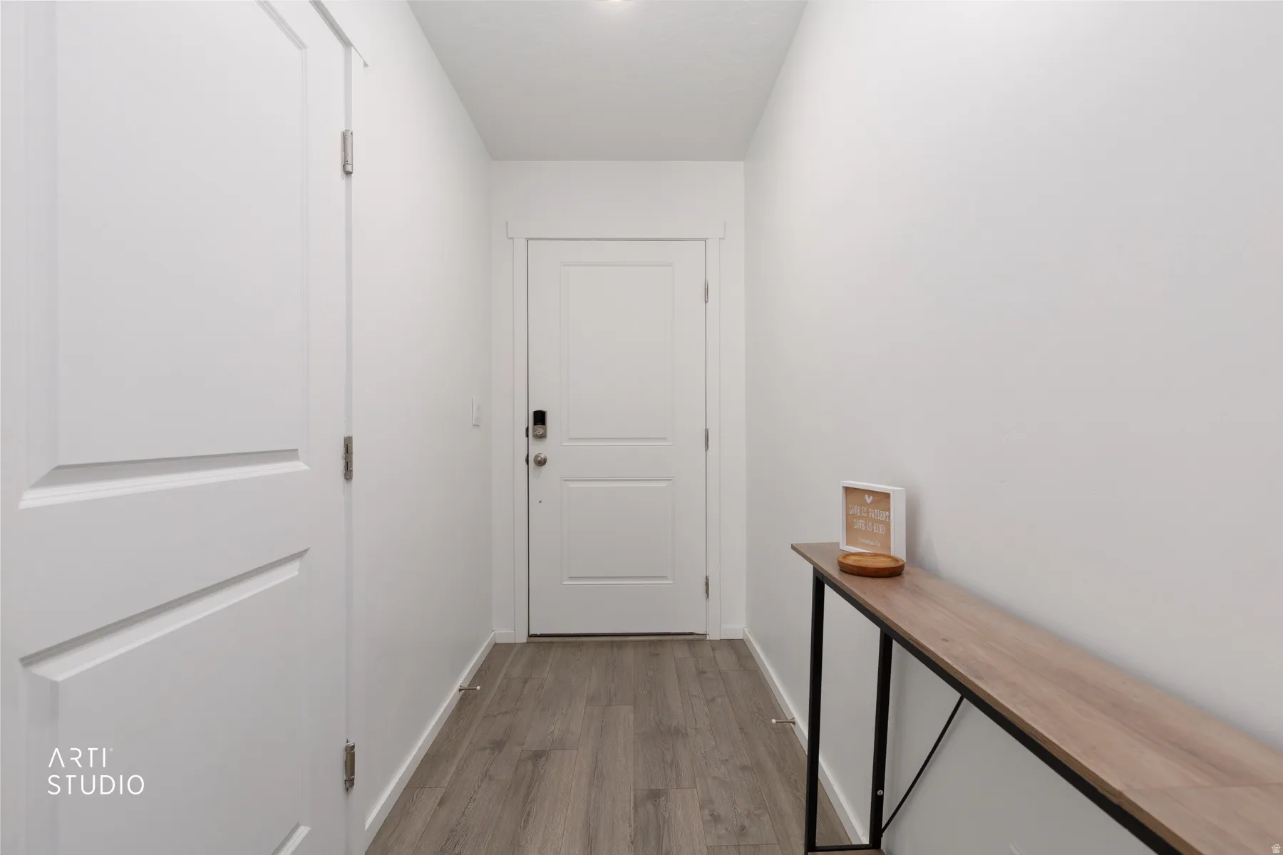 White interior doors, recessed ceiling lighting, wood-finish flooring, and crisp white walls