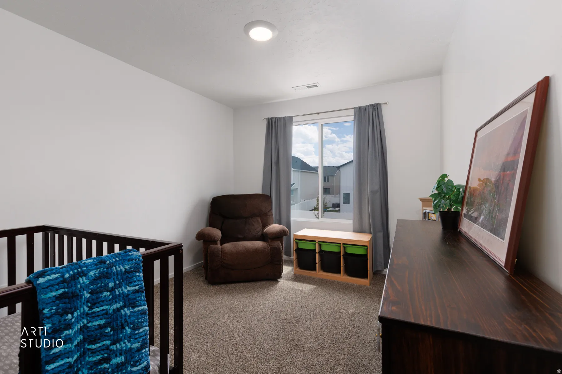 Recessed ceiling lighting, neutral carpeting, and a large window with privacy blinds
