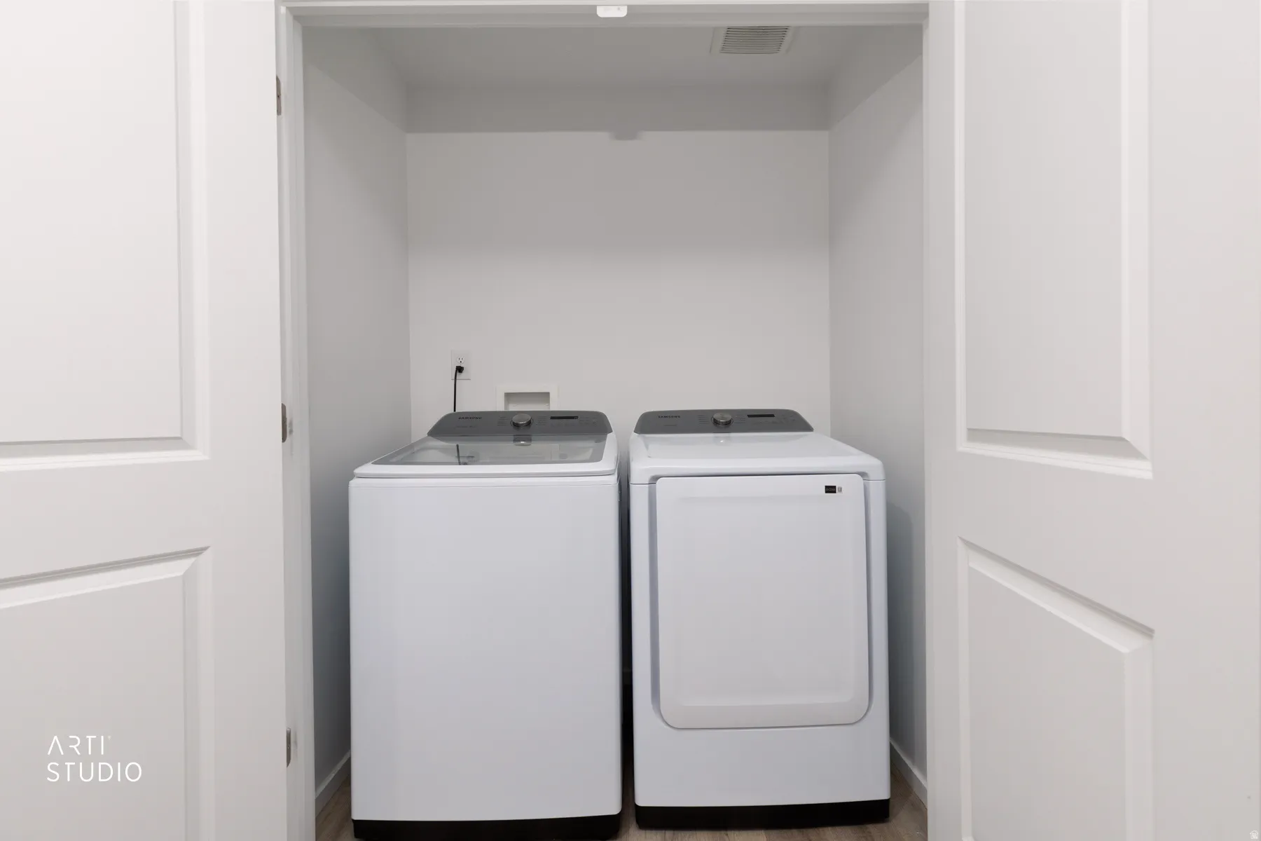 Dedicated laundry closet with wood-finish flooring