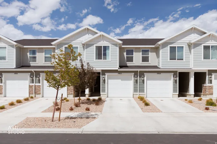 Contemporary townhome exteriors featuring light siding, white trim, and stone accents