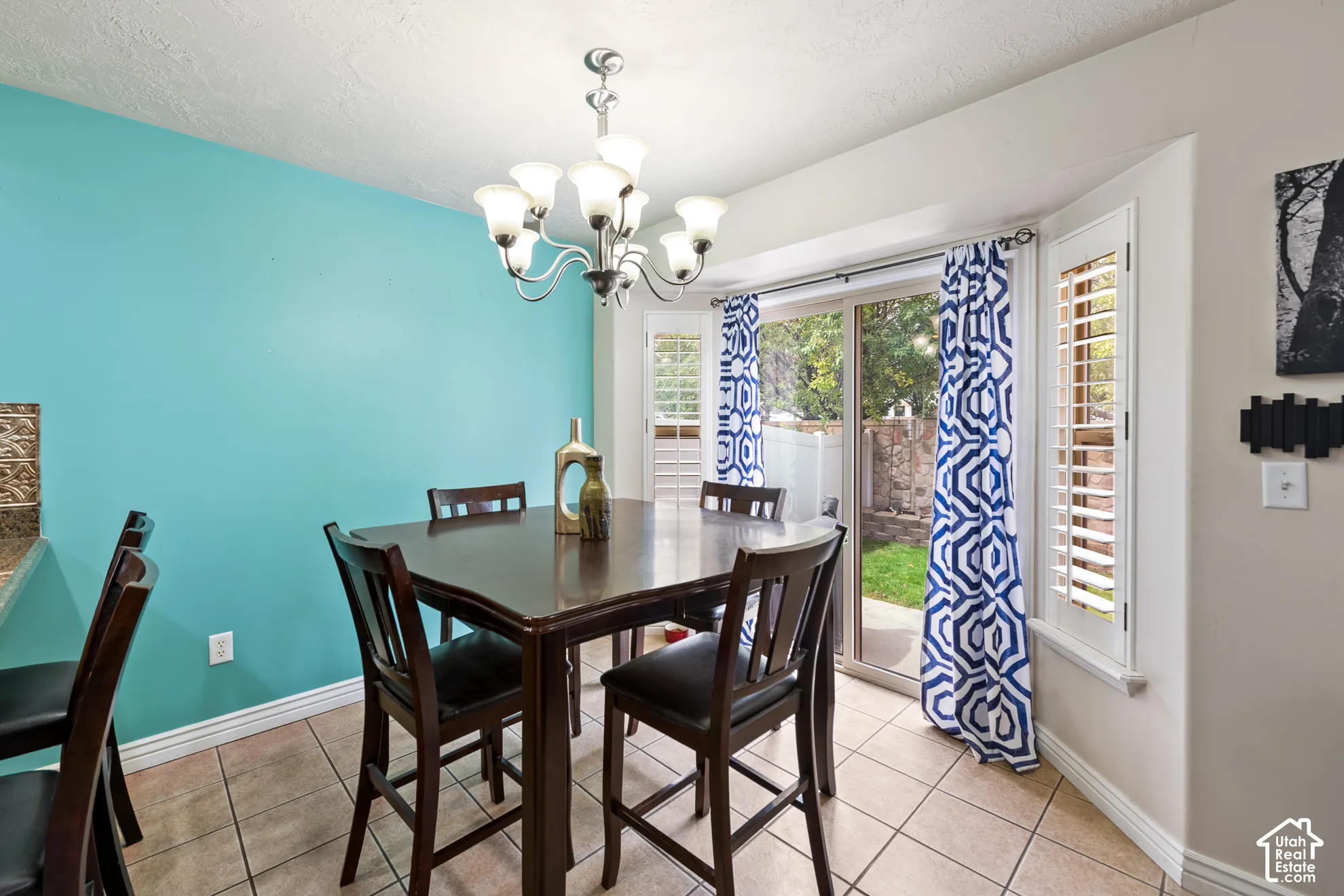 Tile flooring, recessed bay window, sliding glass door, and chandelier lighting