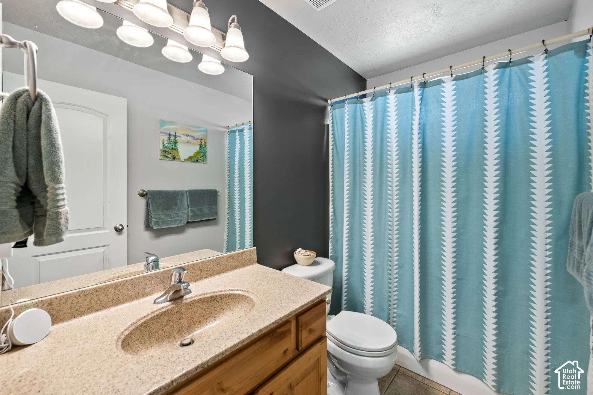 Bathroom featuring a vanity with a speckled countertop, integrated sink, and an overhead light fixture