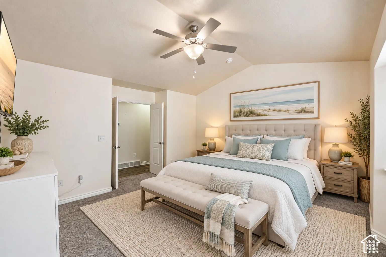 Vaulted ceiling with a central brushed-nickel ceiling fan, neutral wall tones, and plush wall-to-wall carpeting