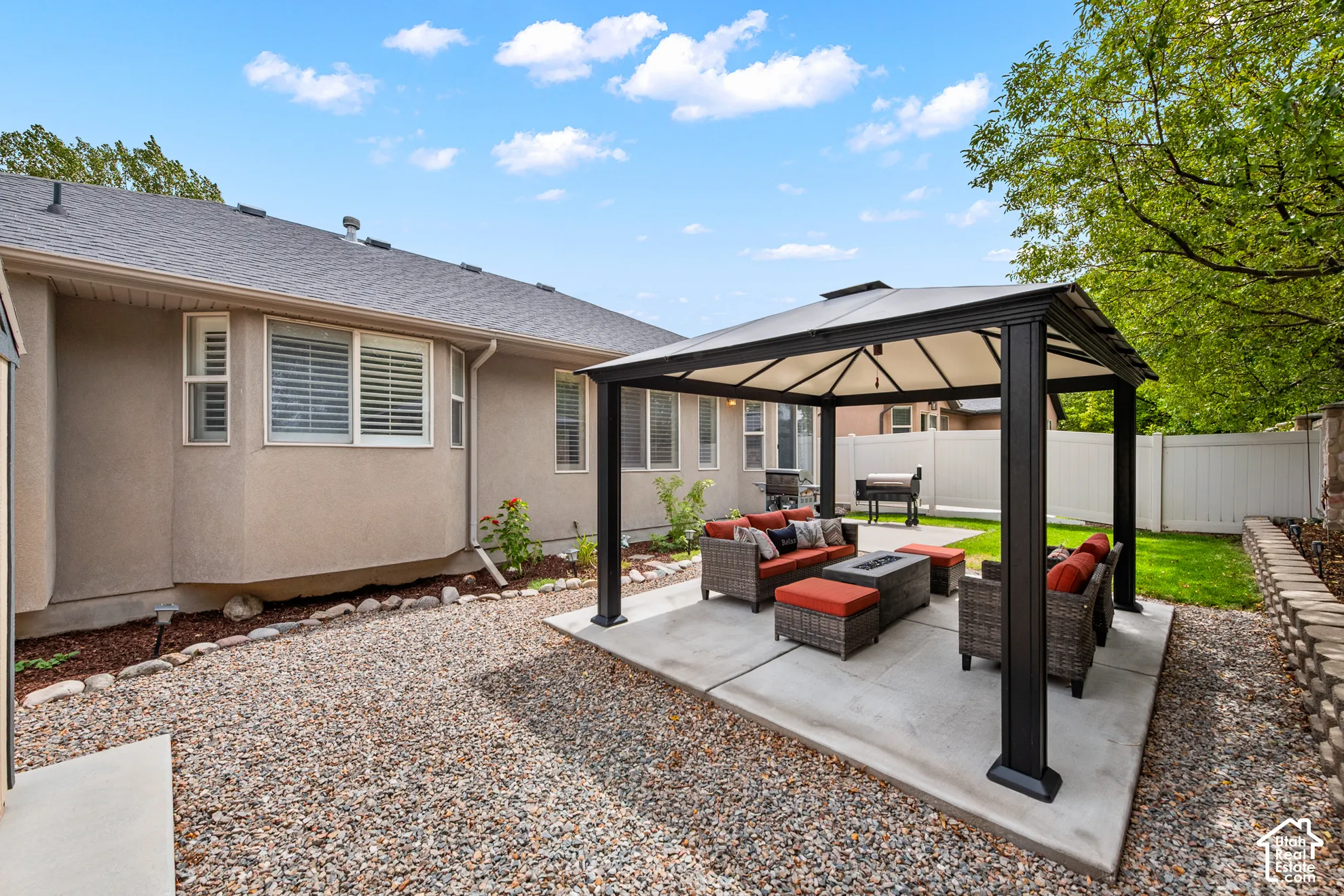Backyard featuring a concrete patio, a gazebo, a privacy fence, and a manicured lawn