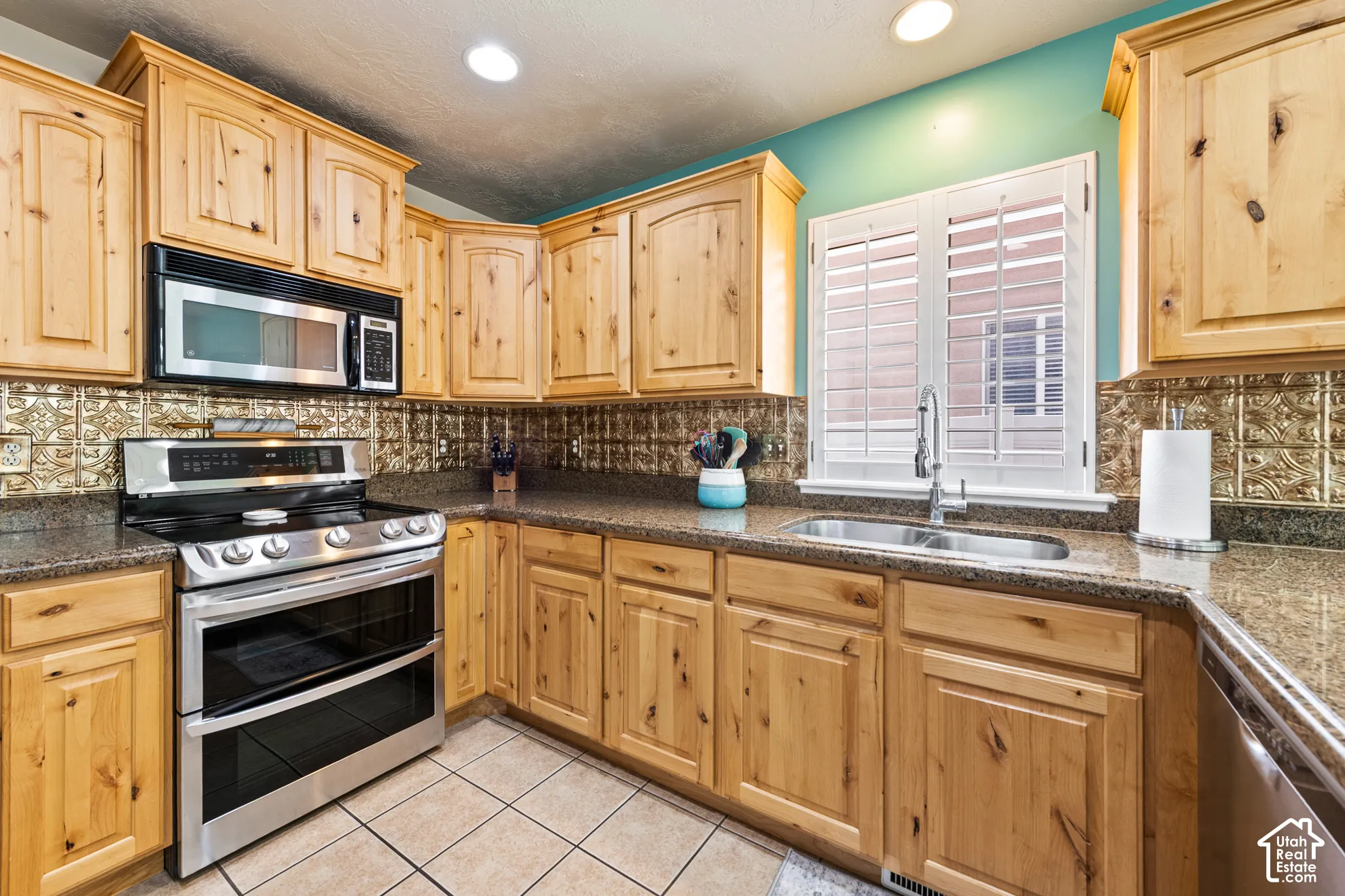 Wood cabinetry with an integrated microwave, stainless steel range, and dishwasher