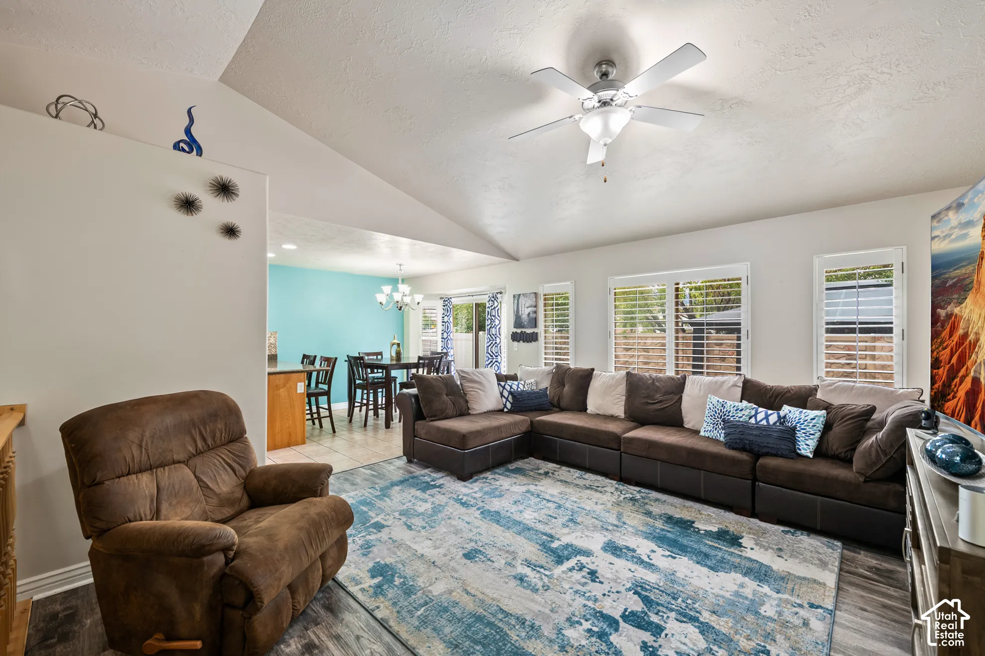 Vaulted ceiling with a ceiling fan, recessed lighting, and wood-finish flooring