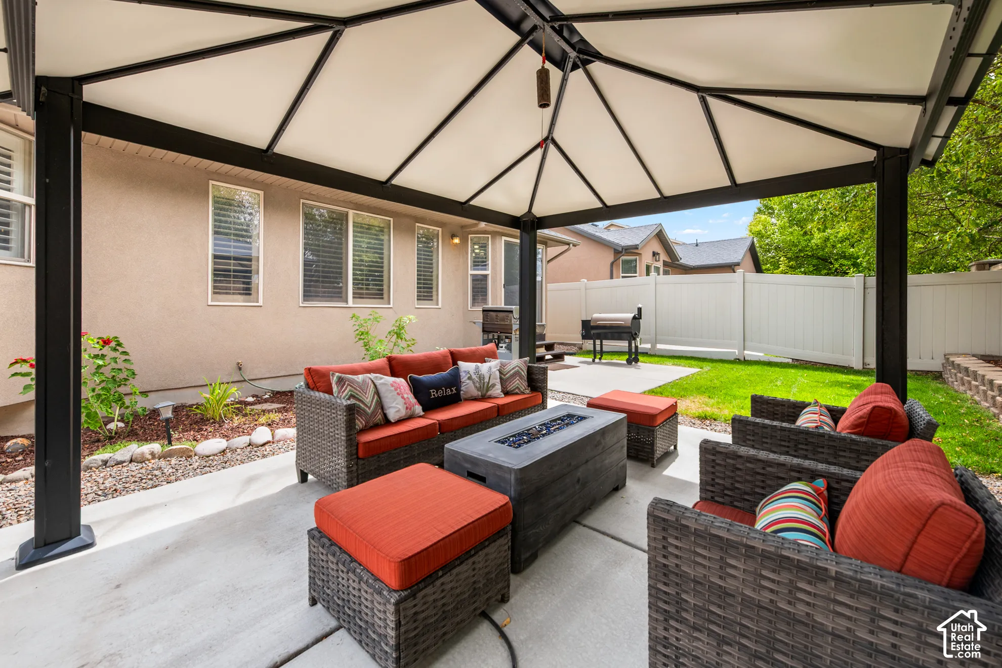 Covered patio with concrete flooring, stucco exterior, and a privacy fence