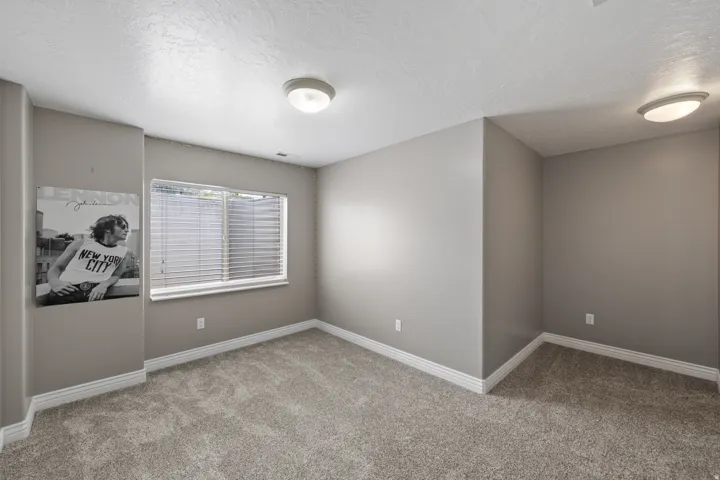Carpeted flooring, neutral wall tones, white trim, and a window with blinds