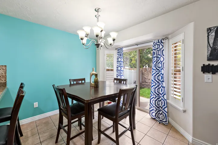 Tile flooring, recessed bay window, sliding glass door, and chandelier lighting