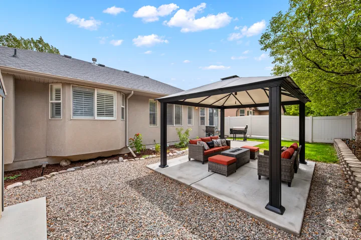 Backyard featuring a concrete patio, a gazebo, a privacy fence, and a manicured lawn