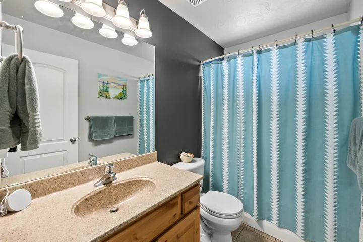 Bathroom featuring a vanity with a speckled countertop, integrated sink, and an overhead light fixture