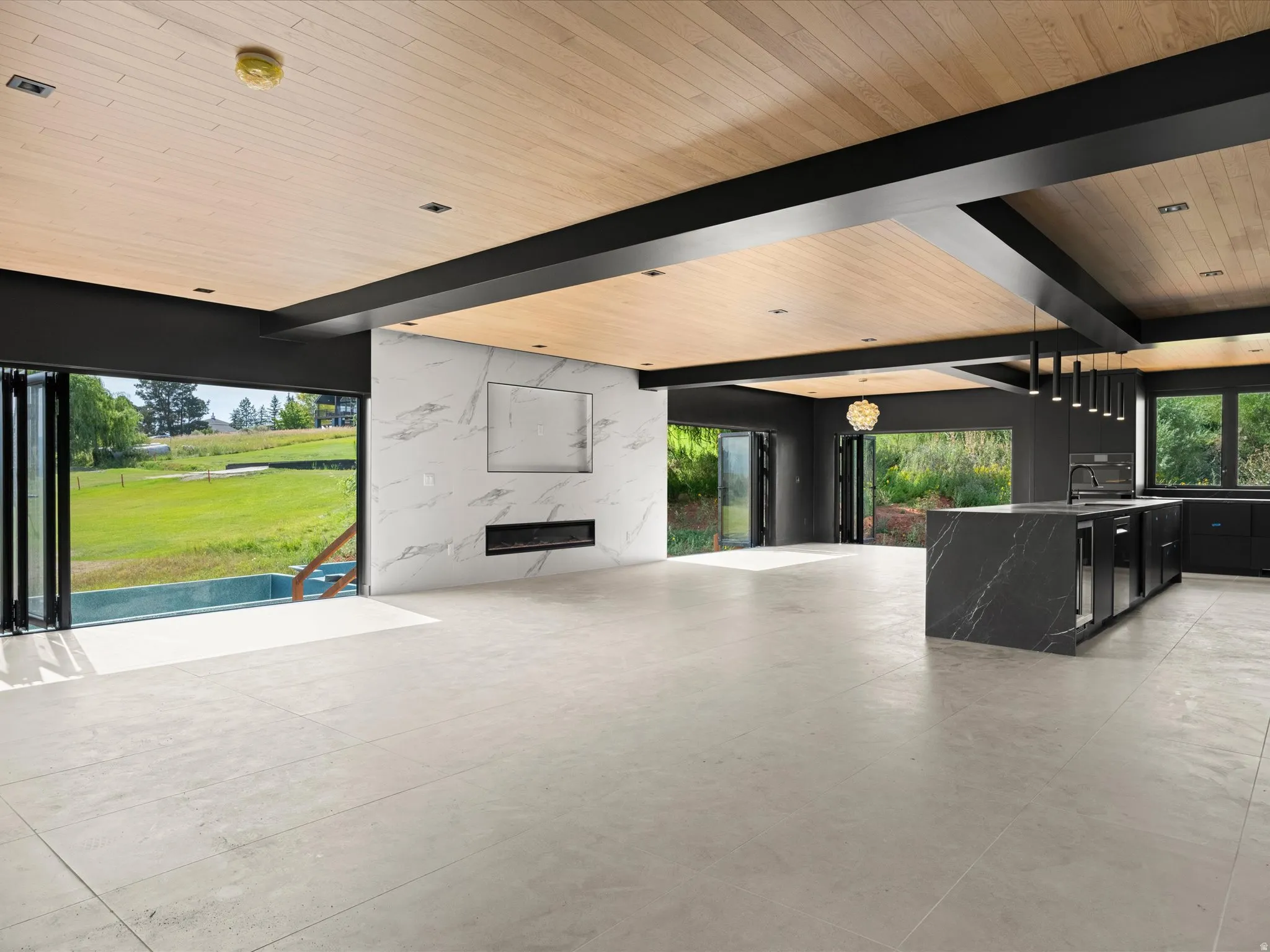 Arizona tile flooring, wood-panel ceiling, dark-finish exposed beams, fireplace with a marble-finish surround, and a dark-finish kitchen island with integrated appliances