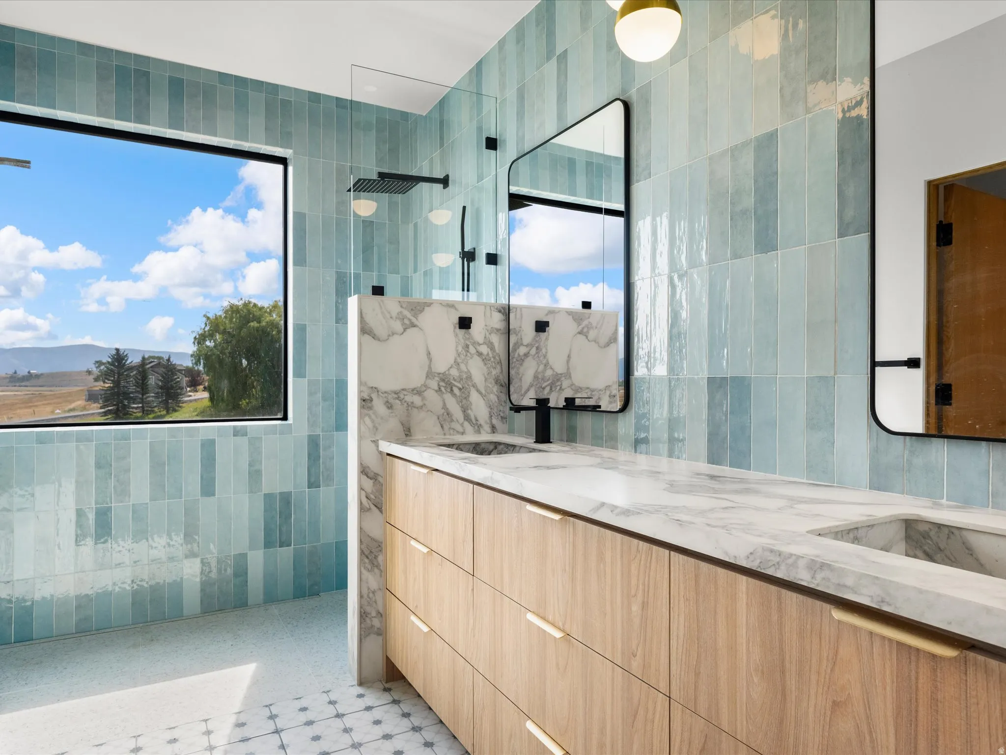 Built-in wood-finish vanity with dual undermount sinks, stone countertop, and custom drawer pulls