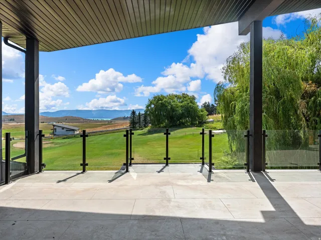 Expansive outdoor patio with glass railing and durable stone-finish flooring