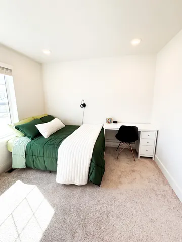 Recessed ceiling lighting, white walls, light-toned carpet, and a window with blinds