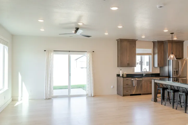 Open-concept living space with light wood-finish flooring, recessed lighting, and a modern ceiling fan