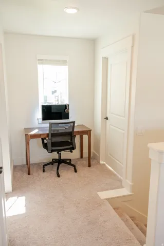 Recessed ceiling lighting, white interior walls, and light-toned carpeting