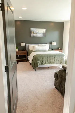 Recessed lighting, light-toned carpeting, and a dark accent wall