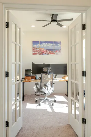French doors with clear glass panes open to a room with light-colored carpeting, recessed lighting, and a ceiling fan