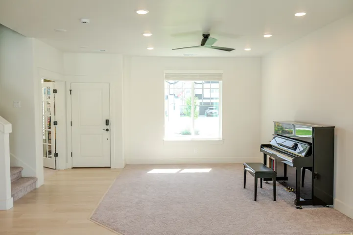 Recessed lighting, wood-finish flooring, two-panel interior doors, light-colored carpeting, and a ceiling fan