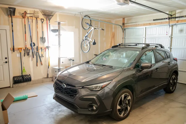 Attached garage with a roll-up door, overhead door opener, and a single window