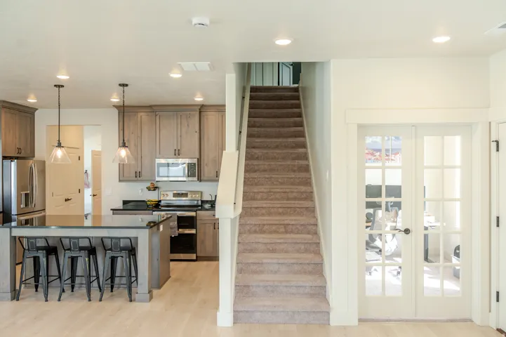 Kitchen featuring wood-finish cabinetry, stainless steel appliances, and a central island with bar seating