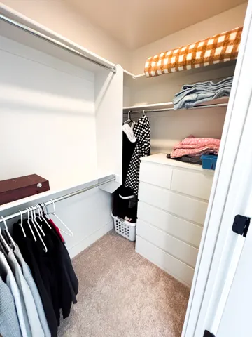 Built-in shelving, multiple hanging rods, and an integrated drawer system