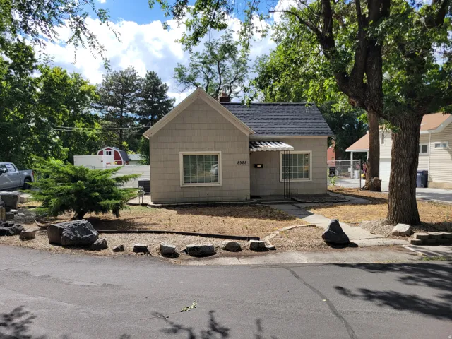 Shingled exterior with a gabled roof and a paved driveway